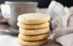 Golden Earl Grey Cookies garnished with powdered sugar, served on a ceramic plate.