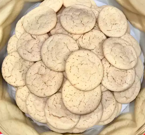 Golden Earl Grey Cookies garnished with powdered sugar, served on a ceramic plate.