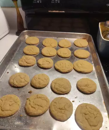 Golden Earl Grey Cookies garnished with powdered sugar, served on a ceramic plate.