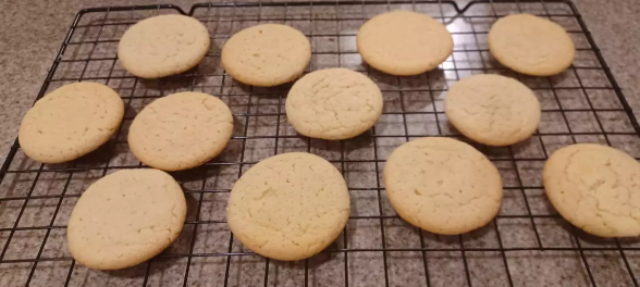 Golden Earl Grey Cookies garnished with powdered sugar, served on a ceramic plate.