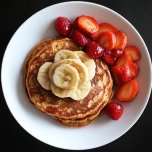 Stack of Protein-Packed Sweet Potato Pancakes with toppings like berries, yogurt, and syrup.